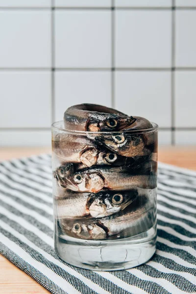 Front view of pile of salted fish in glass on towel — Stock Photo