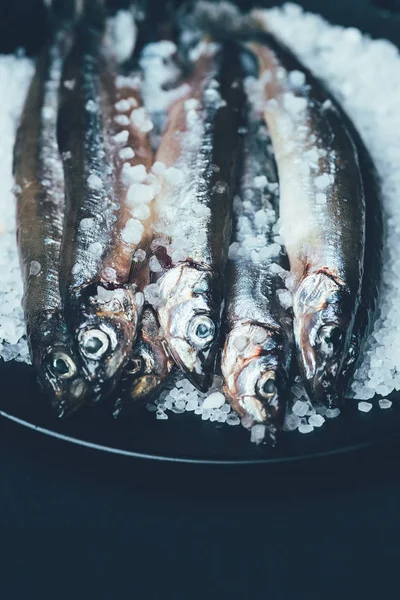 Vista de cerca de la pila de pescado salado en sartén aislado en negro - foto de stock