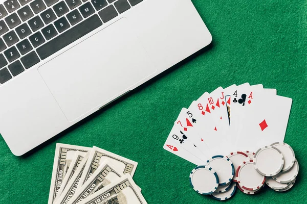 Online gambling concept with cards and money on table by laptop — Stock Photo