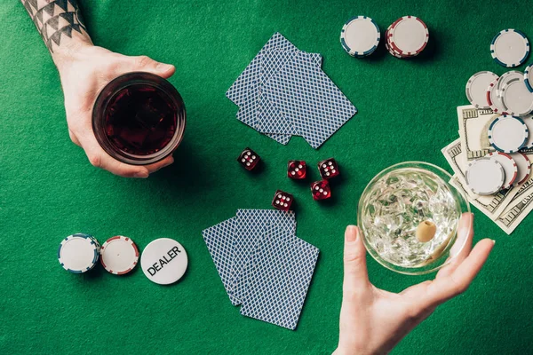 Homme et femme avec boissons jouant à table avec des dés et des cartes — Photo de stock