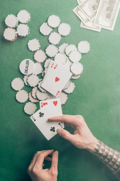 Main masculine avec cartes de poker par table de casino — Photo de stock