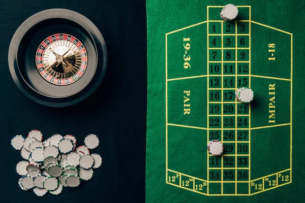 Table de casino avec roulette et jetons ronds — Photo de stock