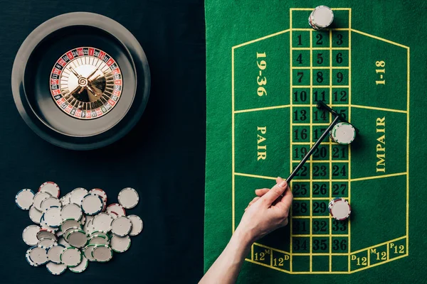 Mulher movendo fichas na mesa do casino com roleta — Fotografia de Stock