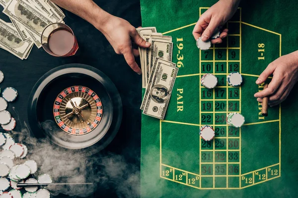 Hommes plaçant un pari sur la table de casino avec roulette — Photo de stock