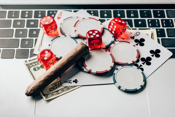 Laptop mit Würfeln und Glücksspielchips auf der Tastatur — Stockfoto