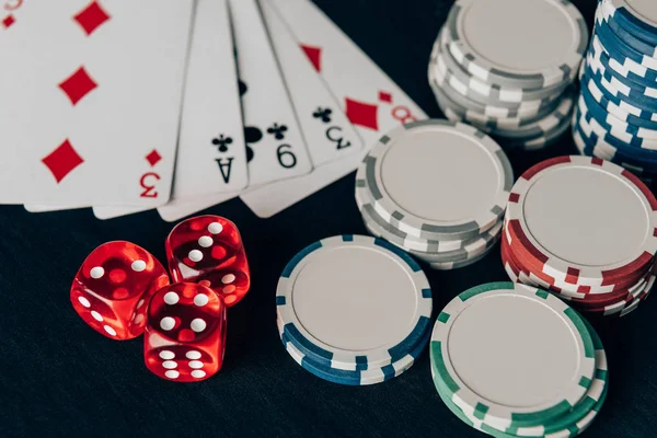 Stacks of chips with dice and playing cards on casino table — Stock Photo