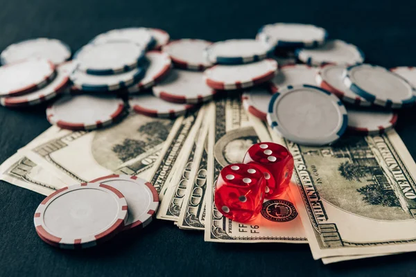Dinero con dados y fichas en la mesa del casino - foto de stock
