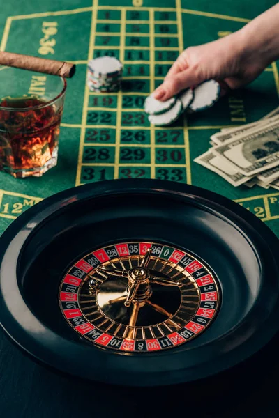 Mujer haciendo una apuesta en la mesa con ruleta - foto de stock