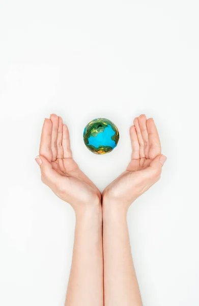 Cropped image of woman holding hands around earth model isolated on white, earth day concept — Stock Photo