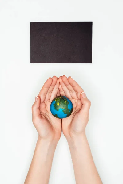 Abgeschnittenes Bild einer Frau, die ein Erdmodell unter einer Tafel hält, isoliert auf weißem, Earth Day-Konzept — Stockfoto