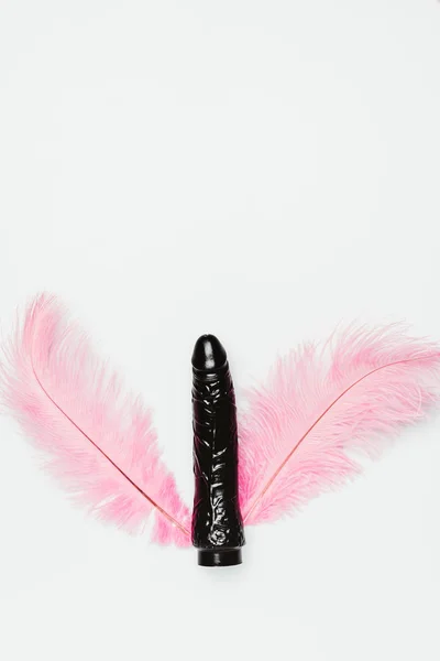Black vibrator toy with pink feathers isolated on white — Stock Photo