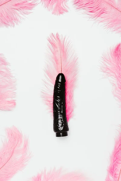 Black dildo toy with pink feathers isolated on white — Stock Photo