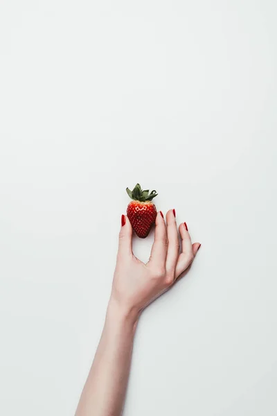 Female hand holding ripe strawberry isolated on white — Stock Photo