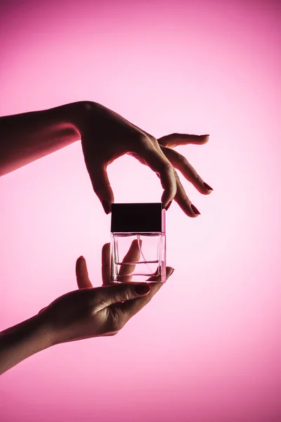 Vista cortada de mãos femininas com perfume, isolado em rosa — Fotografia de Stock