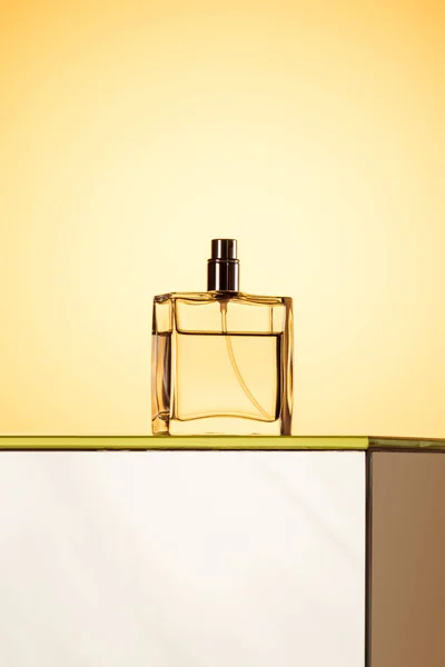 Bottiglia spray elegante con profumo, su giallo — Foto stock
