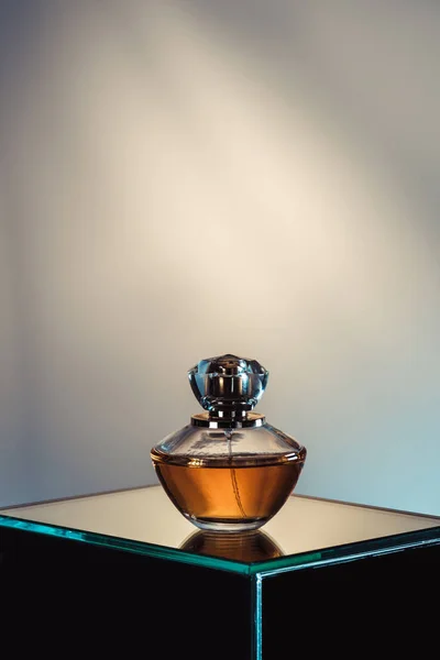 Botella de spray con perfume en la mesa de vidrio - foto de stock
