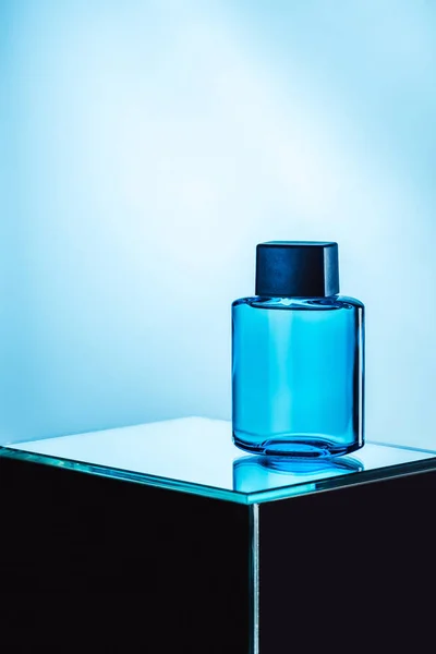 Mens perfume in blue spray bottle, on blue — Stock Photo