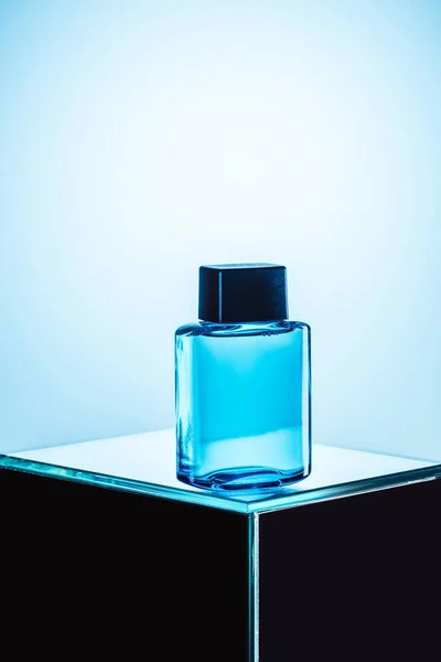 Mens fragrance in blue spray bottle, on blue — Stock Photo