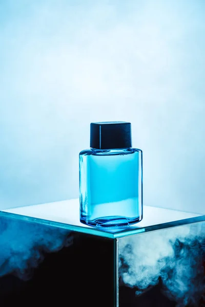 One blue bottle with mens perfume, on blue — Stock Photo
