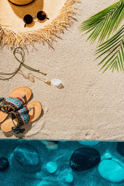 Vista superior de vários acessórios femininos na praia arenosa — Fotografia de Stock