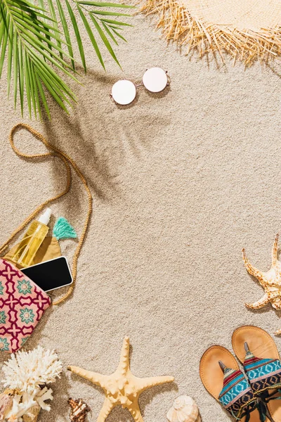 Vue de dessus des accessoires féminins élégants couchés sur la plage de sable — Photo de stock