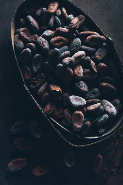 Vista ravvicinata di deliziosi fagioli di cacao sulla superficie scura — Foto stock