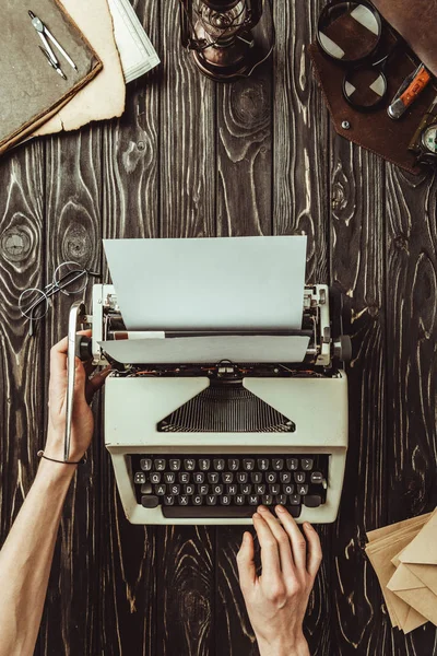 Partial view of writer hands, typing machine and envelopes on wooden tabletop — Stock Photo