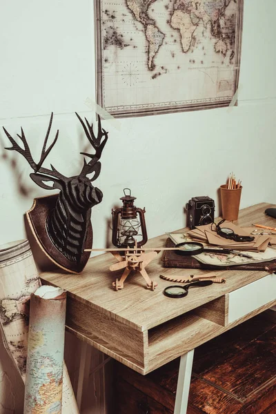 Vue rapprochée du tableau avec carte, loupes, appareil photo rétro et diverses décorations — Photo de stock