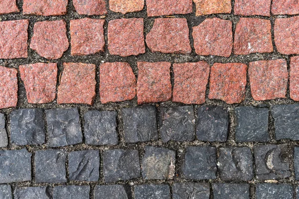 Straßenbelag aus roten und schwarzen Steinen — Stockfoto