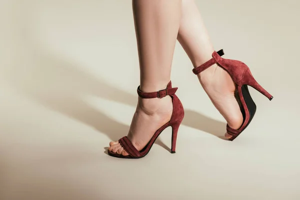 Abgeschnittene Aufnahme von Frauenfüßen in stylischen High Heels auf weißem Hintergrund — Stockfoto