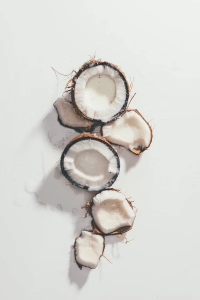Von oben auf Stücke leckerer gesunder Kokosnüsse auf weiß — Stockfoto