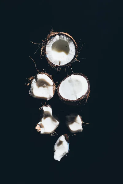 Close-up view of pieces of gourmet healthy organic coconuts on black — Stock Photo