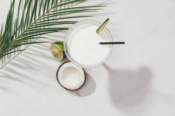 Vue de dessus du cocktail de noix de coco en verre avec de la chaux et de la paille à boire sur blanc — Photo de stock