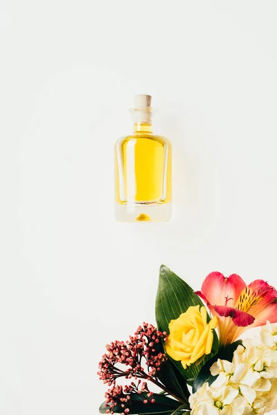 Draufsicht auf eine Flasche Parfüm mit bunten Blumen, isoliert auf weiß — Stockfoto