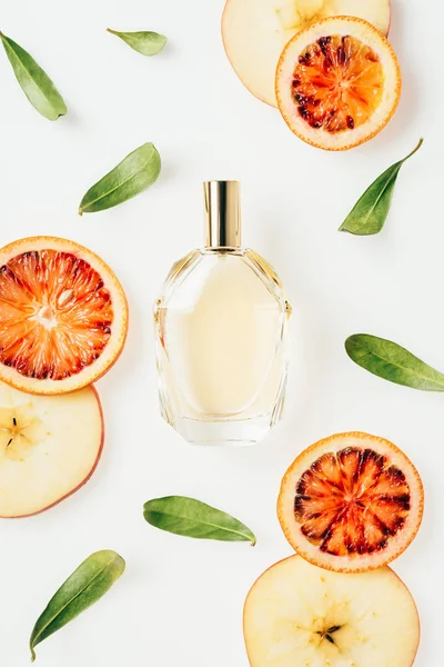 Draufsicht auf Flasche mit frischem Parfüm umgeben von Früchten und Blumen isoliert auf weiß — Stockfoto
