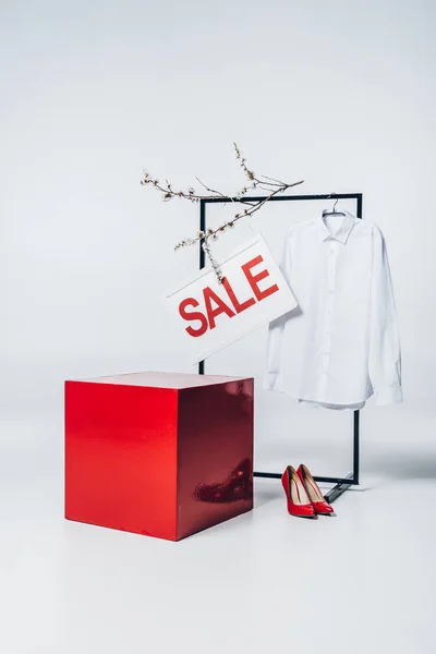 Cubo vermelho, salto alto, camisa no gancho e sinal de venda, conceito de venda de verão — Fotografia de Stock