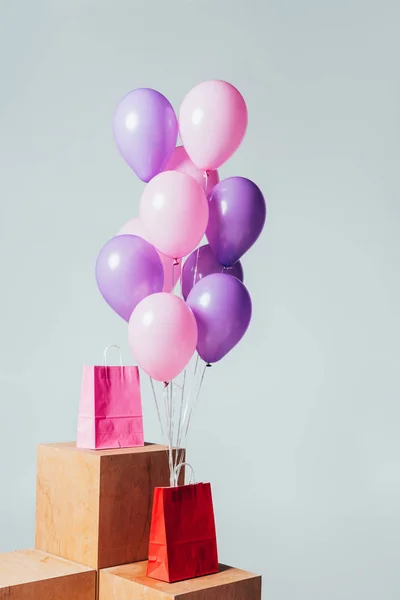 Red and pink shopping bags with bundle of balloons isolated on white, summer sale concept — Stock Photo