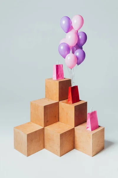 Red and pink shopping bags with bundle of balloons, summer sale concept — Stock Photo