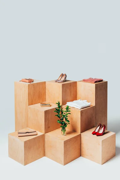 Vue grand angle des talons hauts et des brindilles dans le vase sur des stands en bois, concept de vente d'été — Photo de stock