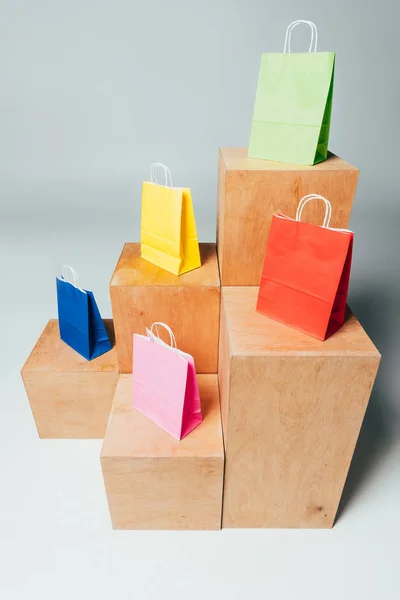 Vue grand angle des sacs à provisions colorés sur des stands en bois, concept de vente d'été — Photo de stock