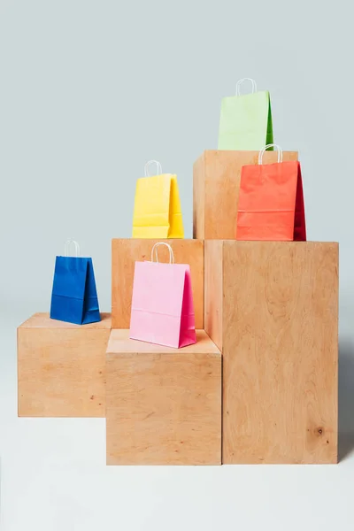Sacos de papel coloridos em estandes de madeira, conceito de venda de verão — Fotografia de Stock