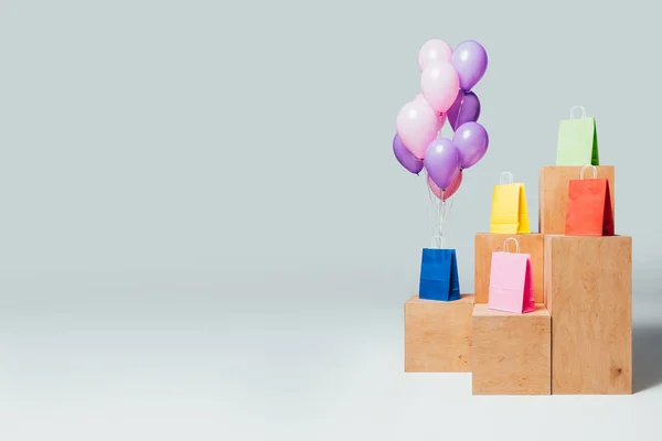 Bundle of balloons near shopping bags on stands, summer sale concept — Stock Photo