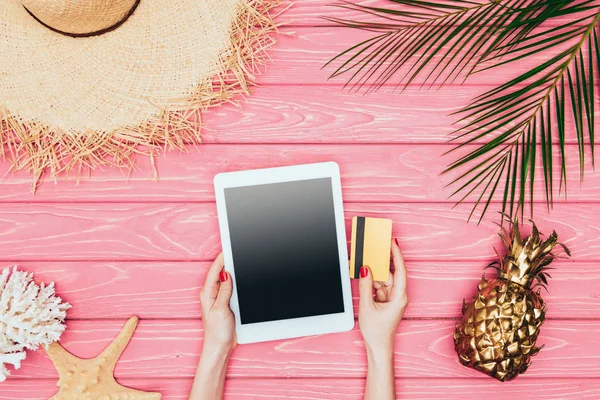 Foto ritagliata di donna in possesso di tablet digitale con carta di credito su superficie di legno rosa con ananas dorato — Foto stock