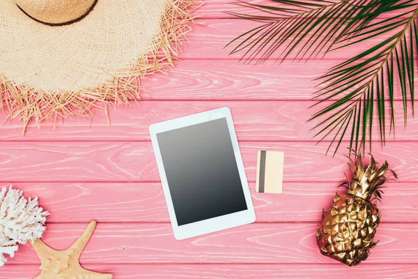 Draufsicht auf digitales Tablet mit Kreditkarte und goldener Ananas auf rosa Holzoberfläche — Stockfoto