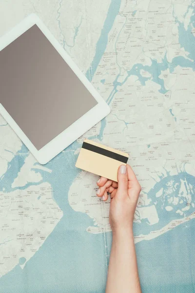 Recortado tiro de con tableta y tarjeta de crédito en el mapa de viajes - foto de stock