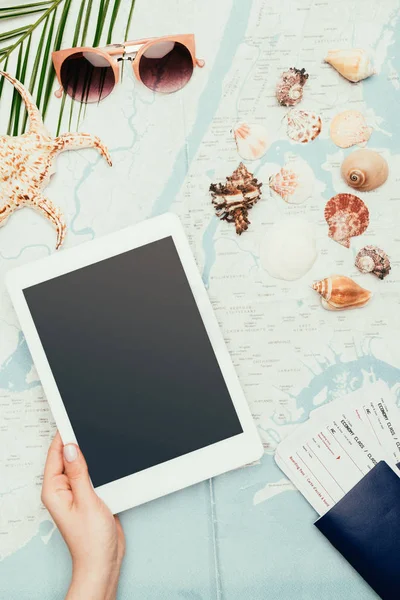 Foto recortada de la mujer con tabletas digitales y billetes de avión en el mapa de viajes - foto de stock