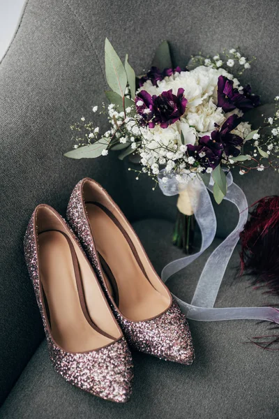 Vue rapprochée des chaussures de mariée et bouquet pour mariage rustique sur fauteuil — Photo de stock