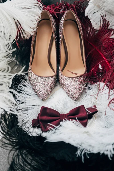 Close up view of bridal shoes, grooms bow tie and feathers for rustic wedding — Stock Photo