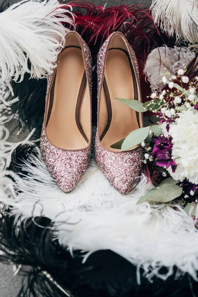 Vue rapprochée des chaussures de mariée, bouquet de mariage et plumes pour mariage rustique — Photo de stock