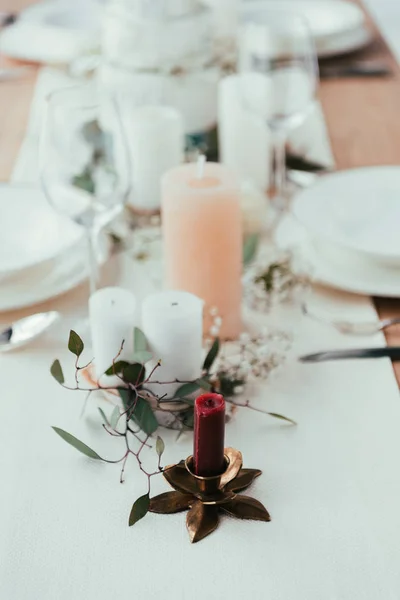 Close up view of stylish table setting with candles, wineglasses and eucalyptus for rustic wedding — Stock Photo